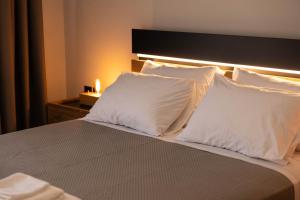 a bed with two white pillows on top of it at Aesthe Suites Noir in Xanthi
