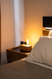 a bed with a night stand with a candle on it at Aesthe Suites Noir in Xanthi
