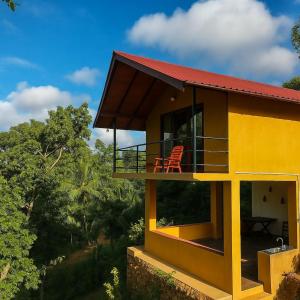 a yellow house with a red roof at Sunshine Forest Lodge - Sinharaja in Deniyaya
