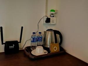 a tea kettle and two bottles of water on a tray at Sunshine Forest Lodge - Sinharaja in Deniyaya