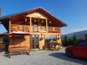 a house with an umbrella in front of it at La Ianis in Vatra Dornei