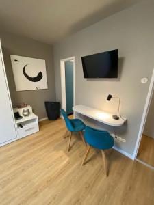 a room with a desk and two blue chairs at Modernes Apartment no5 in bester Stadtlage in Kassel