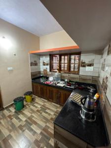 a kitchen with a black counter top in a room at Podanolana residency- Sleep Above the Clouds in Madikeri