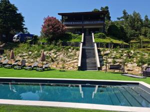 a house with a swimming pool in front of a house at Abadia House - Geres in Geres