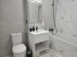 a white bathroom with a toilet and a sink at Apartament nou si modern lanaga metrou in Bucharest +33 photos