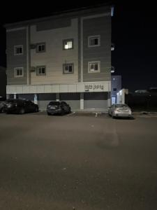 a building with two cars parked in a parking lot at Safety house in Tabuk