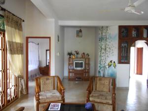 Una sala de estar con dos sillas y un televisor. en Accoma Villa, en Hikkaduwa