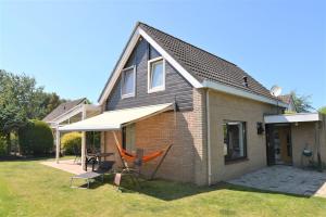 une maison avec un hamac dans la cour dans l'établissement Vakantiehuis Mosselbank 22, loopafstand van strand VP070, à Ouddorp