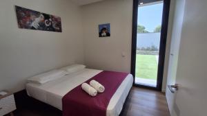 ein Schlafzimmer mit einem Bett mit zwei weißen Handtüchern darauf in der Unterkunft Villa moderna piscina balinesa cerca de la Playa in Novo Sancti Petri + 32 Fotos