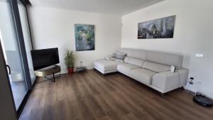 ein Wohnzimmer mit Sofa und Fernseher in der Unterkunft Villa moderna piscina balinesa cerca de la Playa in Novo Sancti Petri