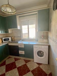 a kitchen with green cabinets and a washing machine at La Torre in Tózar
