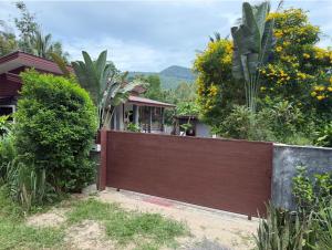 ein Holzzaun vor einem Haus in der Unterkunft Stylish Island Villa with Garden in Ko Phangan