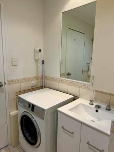 a bathroom with a washing machine and a sink at 806 Deluxe Delight Concert Hall Studio in Perth