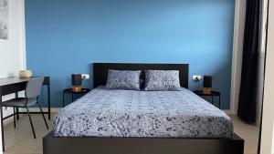 Un dormitorio con una cama con una pared azul. en Besonderes Apartment mit einzigartigem Meerblick, en Costa Calma 45 fotos más