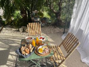 a table with a plate of food and two chairs at Chambre élégante avec terrasse in Souvigny