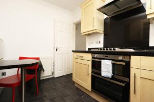 a kitchen with a black stove and a table at Ideal Bath House by St James’s Park in Bath