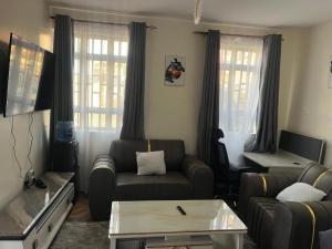 a living room with a couch and a table at Sahel Executive Studio apartment with separate kitchen and bathroom in another section from the main room for cheap accommodation in Elgon View near Eldoret sports club,Rapha Hospital, Naivas supermarket, rupha mall, and Eldoret International Airport in Eldoret