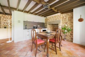 una cucina con tavolo e sedie in legno in una stanza di La Maison de Montsecret - Maison paisible pour 6p a Valdallière