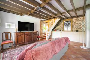 un soggiorno con divano e TV a schermo piatto di La Maison de Montsecret - Maison paisible pour 6p a Valdallière