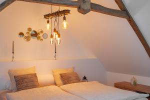 una camera da letto con un letto e un lampadario di La Maison de Montsecret - Maison paisible pour 6p a Valdallière