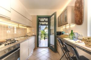 a kitchen with a counter with chairs in it at Villino Le Pavoncelle in Torre delle Stelle