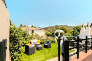 a balcony with couches and chairs on the grass at Villino Le Pavoncelle in Torre delle Stelle