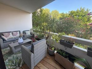 a patio with chairs and plants on a balcony at Appartement calme à Anglet in Anglet
