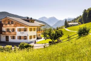 a house on a hill with mountains in the background at Lacklehen in Ramsau