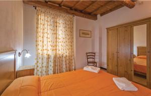 1 dormitorio con 1 cama grande de color naranja con silla en Fattoria Il Santo, en Santo