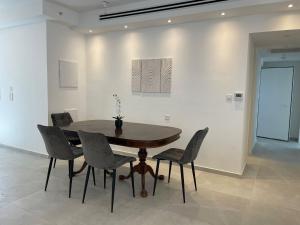 a dining room with a wooden table and chairs at Beach Suite Israel - 12th Floor Marina & Beach Views 3 Bedrooms ביץ סוייט ישראל של אשקלון - דירת נופש קומה 12 נוף מאלף למרינה וים, 3 חדרי שינה in Ashkelon