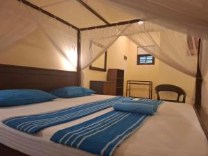 a large bed with blue pillows in a bedroom at Blue Point Rest in Tangalle