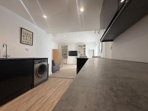 a living room with a washing machine in a room at Stylish 3 bed spacious flat in Brentwood