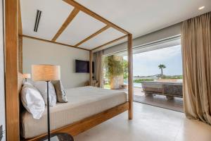 a bedroom with a bed and a view of a pool at Villa Zelmar - Tranquility and Privacy in Cala Conta in Sant Josep de Sa Talaia +41 photos