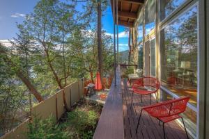a balcony of a house with red chairs on it at Bright, Contemporary, Walk To Town & Beach in Eastsound