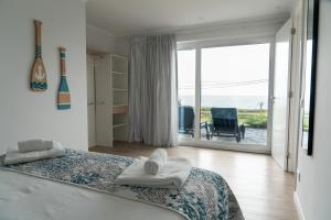 a bedroom with a bed and a view of the ocean at Villas da Salga in Angra do Heroísmo