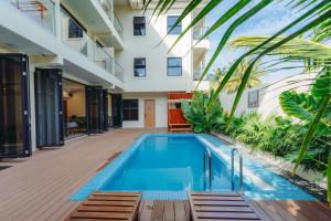 a swimming pool in front of a building with a house at Aire Dharavandhoo in Dharavandhoo