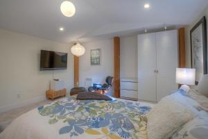 a bedroom with a large bed and a tv at Bright, Contemporary, Walk To Town & Beach in Eastsound