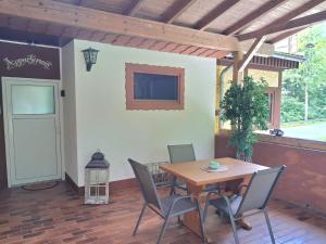 a patio with a wooden table and chairs and a door at Ferienapartment Waldhaus in Marsberg