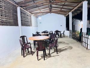 a group of tables and chairs in a patio at Won Happy Hotel - Kitulgala in Kitulgala