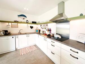 a kitchen with white cabinets and stainless steel appliances at The Barn at Orford Lodge by The Suffolk Cottage Collection in Orford +23 photos