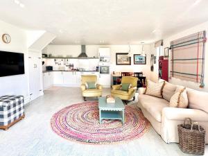 a living room with a couch and a table at The Barn at Orford Lodge by The Suffolk Cottage Collection in Orford