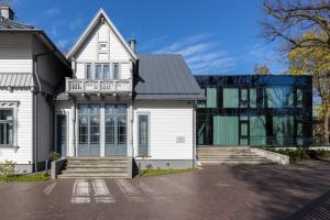 a white house with a black roof at Roze Peldu Residence in Liepāja