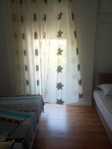 a room with two beds and a window with stars at Beta Holidays in Vlorë