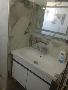 a bathroom with a white sink and a mirror at Beta Holidays in Vlorë +15 photos