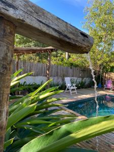 Una piscina en el patio trasero con una pérgola de madera y una silla. en Redondo Trancoso, en Trancoso 25 fotos más