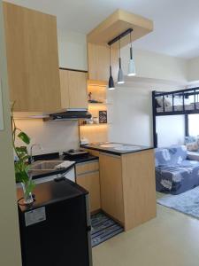 una cocina con fregadero y un sofá en una habitación en The Comfort Pad Avida 2, en Cagayan de Oro