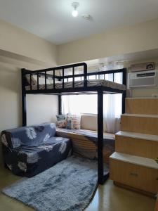 Un dormitorio con una litera y una escalera. en The Comfort Pad Avida 2, en Cagayan de Oro