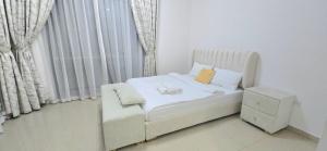 アジュマーンにあるLuxury 4 Bedroom Apt with Complimentary Access to Hotel Private Beach,GYM&Swimming Poolの窓付きの客室で、小さな白いベッド1台が備わります。 +38枚の写真