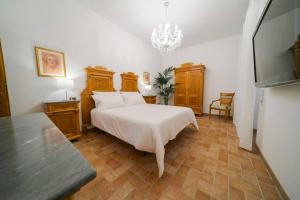 a bedroom with a white bed and a chandelier at Domus Emma in Cantalupo in Sabina