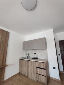 a white kitchen with a sink and a counter at Guesthouse Nesa in Ulcinj +8 photos